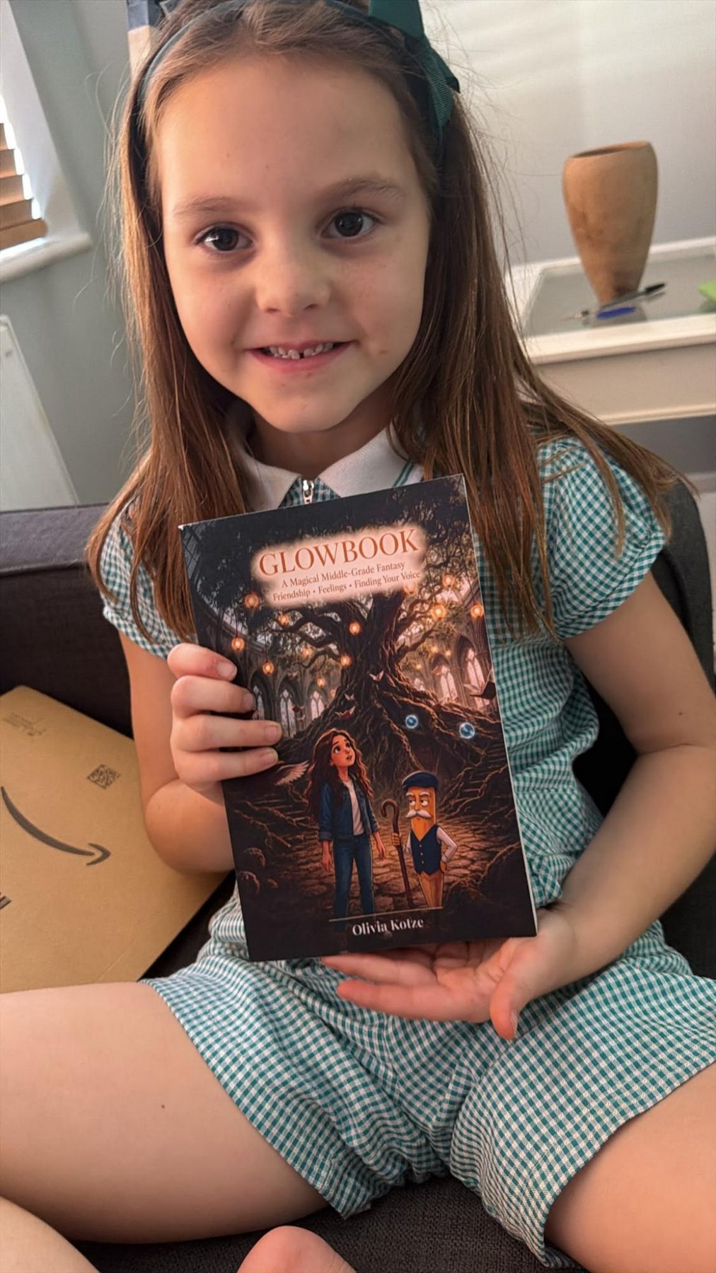 A girl in school uniform holding her paperback copy of GlowBook.
